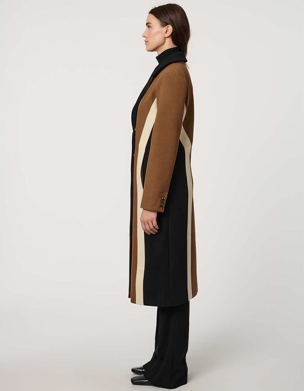 A profile of a model standing tall in a color block jacket for women.