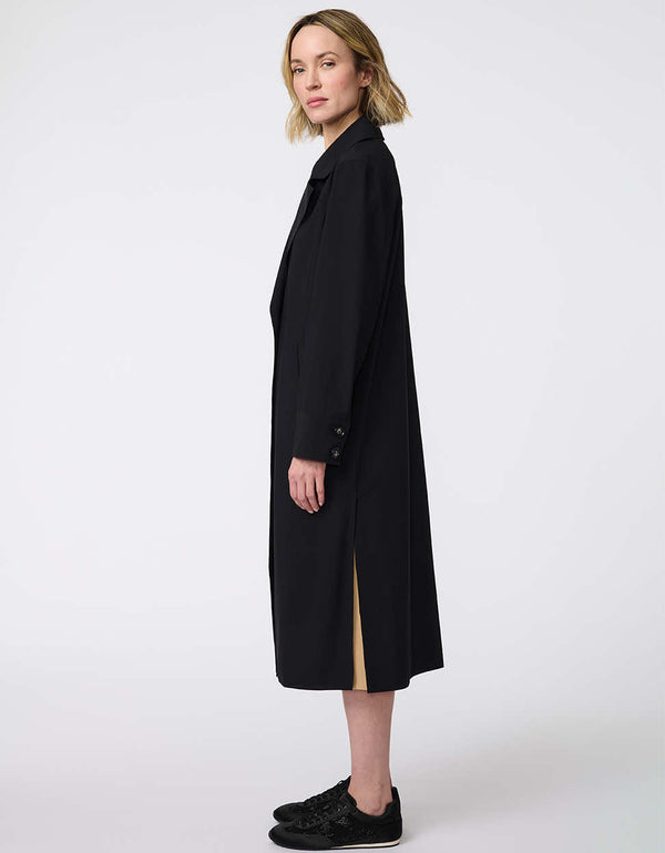 Women's Voyager Stretch Duster, a long, travel-ready jacket with a single-button closure and deep pockets for on-the-go versatility.