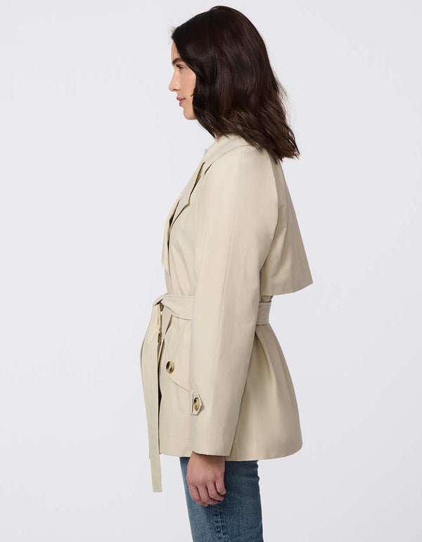 Women's cropped trench coat in a bone color, featuring a double-breasted front and  belted waist. A modern take on the timeless trench, perfect for layering in transitional weather.