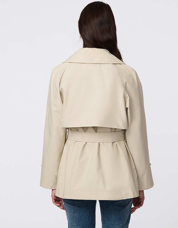 Women's cropped trench coat in a bone color, featuring a double-breasted front and  belted waist. A modern take on the timeless trench, perfect for layering in transitional weather.