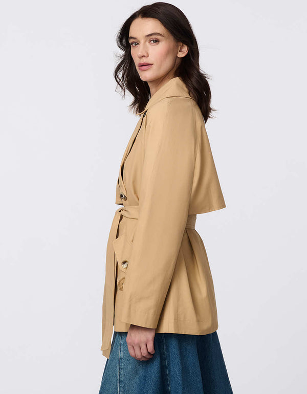 Women's cropped trench coat in a bone color, featuring a double-breasted front and  belted waist. A modern take on the timeless trench, perfect for layering in transitional weather.