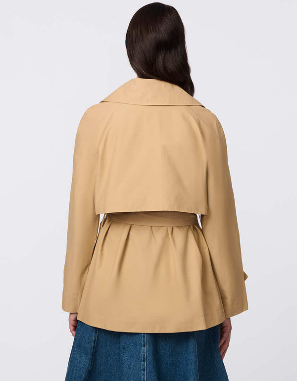 Women's cropped trench coat in a bone color, featuring a double-breasted front and  belted waist. A modern take on the timeless trench, perfect for layering in transitional weather.