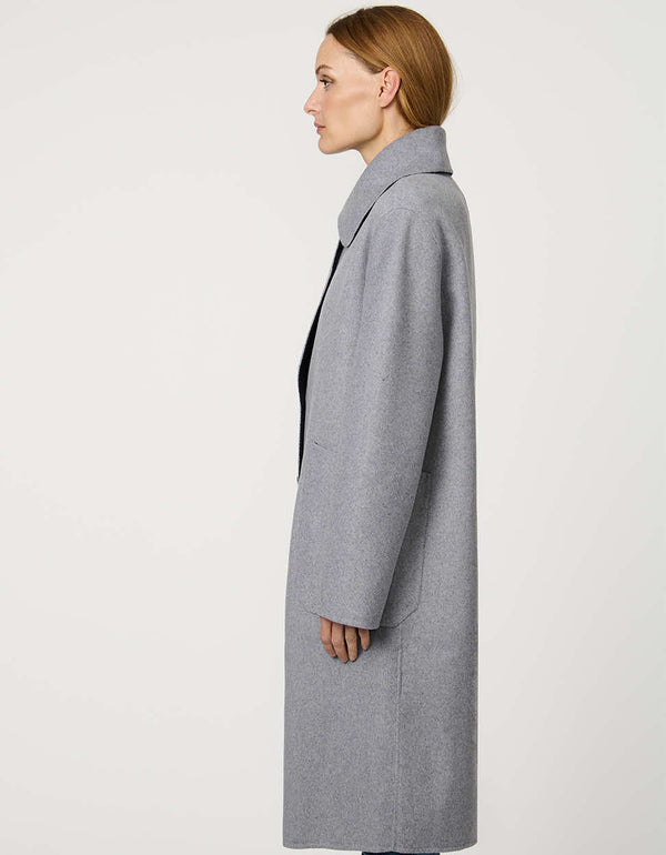 Women’s plaid wool coat with oversized calf-length fit, dramatic collar, and two-button single-breasted front.