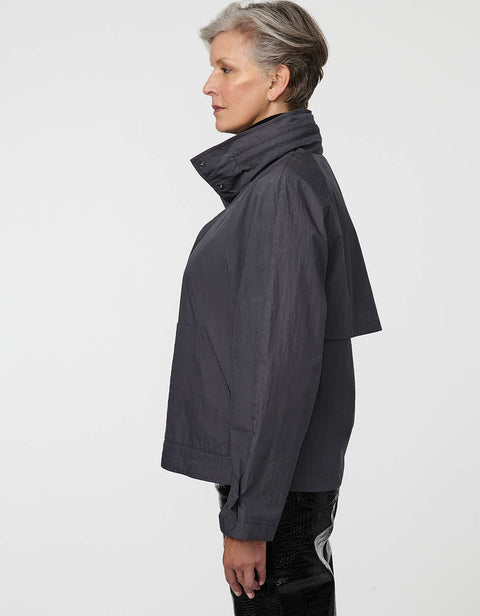 Waist-length water-repellent jacket with roll-away hood and patch pockets, designed for everyday layering.