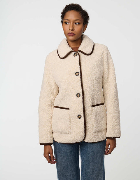 Plush sherpa coat with contrast trim, tortoise shell buttons, and patch pockets for cozy styling.