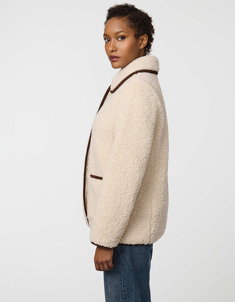 Plush sherpa coat with contrast trim, tortoise shell buttons, and patch pockets for cozy styling.
