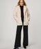 Woman wearing a cream sherpa coat on a white background