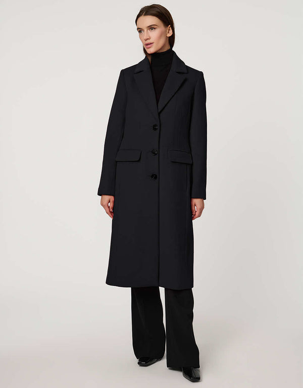 Women’s knee-length wool coat with tailored darts, patch pockets, and single-breasted three-button front.