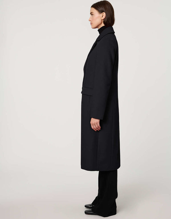 Women’s knee-length wool coat with tailored darts, patch pockets, and single-breasted three-button front.