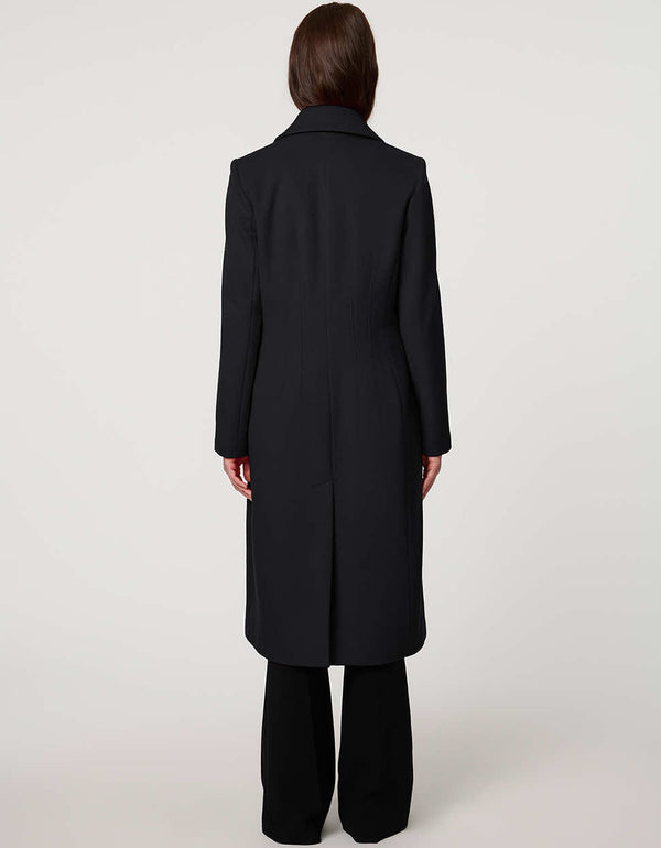 Women’s knee-length wool coat with tailored darts, patch pockets, and single-breasted three-button front.