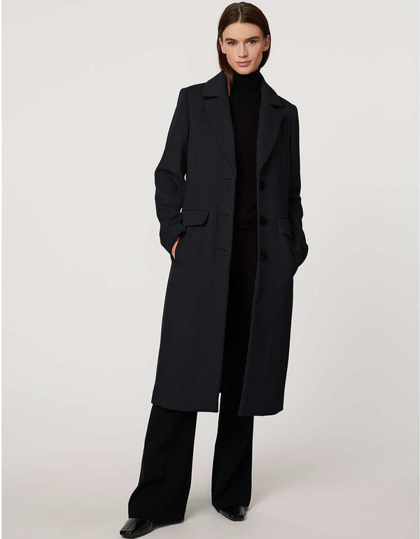 Women’s knee-length wool coat with tailored darts, patch pockets, and single-breasted three-button front.