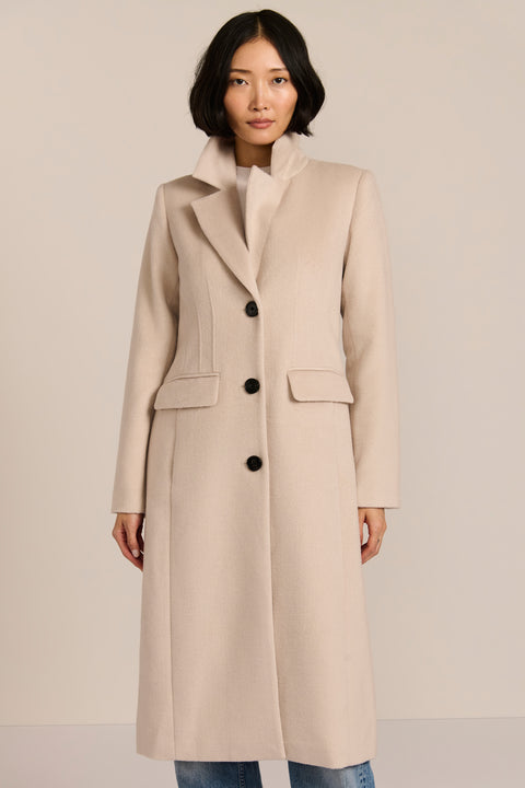 Women’s knee-length wool coat with tailored darts, patch pockets, and single-breasted three-button front.