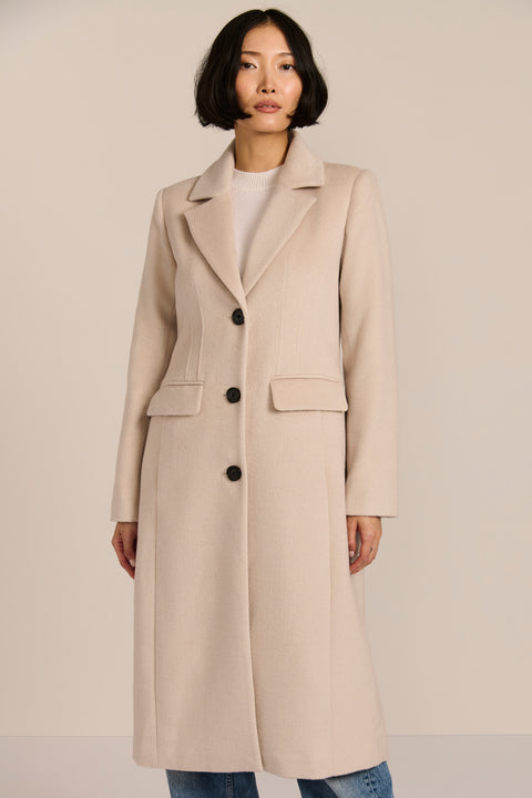 Women’s knee-length wool coat with tailored darts, patch pockets, and single-breasted three-button front.