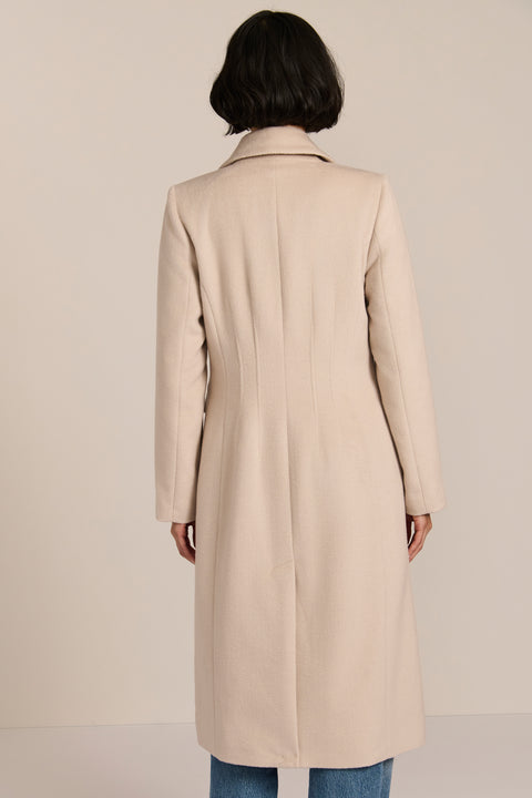 Women’s knee-length wool coat with tailored darts, patch pockets, and single-breasted three-button front.