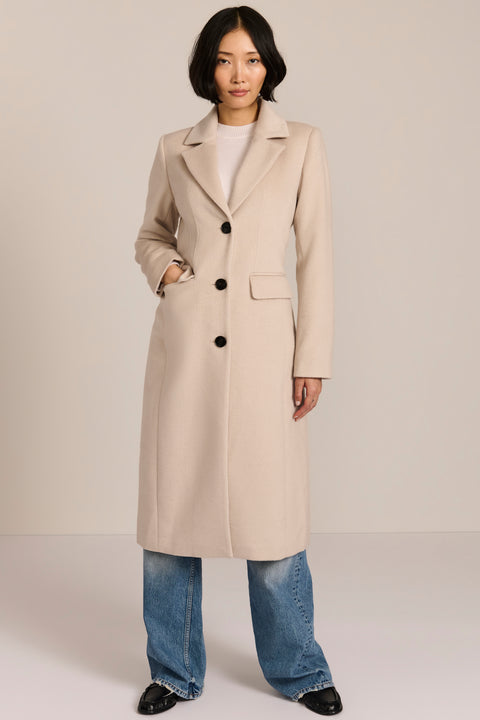 Women’s knee-length wool coat with tailored darts, patch pockets, and single-breasted three-button front.
