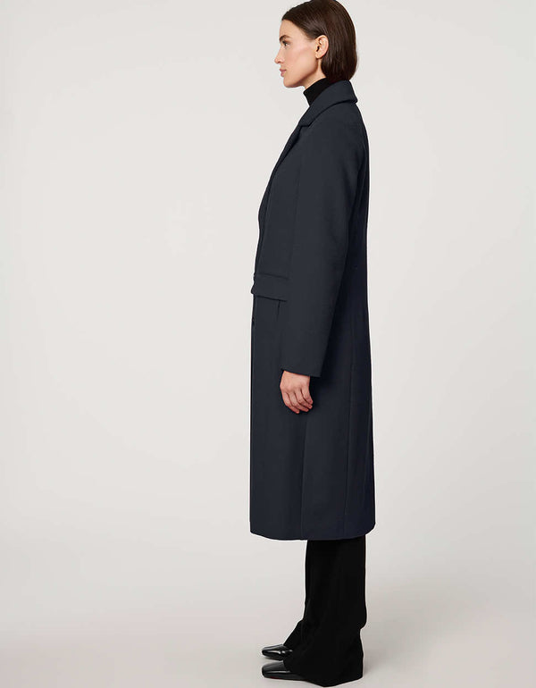 Women’s knee-length wool coat with tailored darts, patch pockets, and single-breasted three-button front.