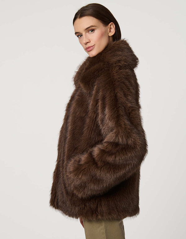 Hip-length faux fur coat with oversized collar, four-button single-breasted front, and welt pockets.