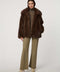 Hip-length faux fur coat with oversized collar, four-button single-breasted front, and welt pockets.