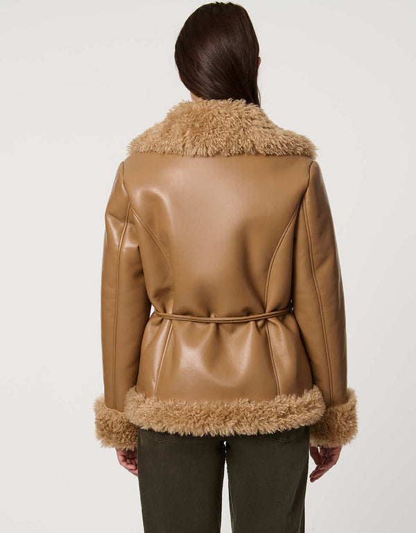 Brown leather jacket with fur trim worn by a person on a white background