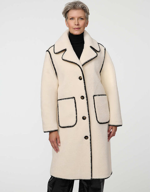 Calf-length faux fur coat with scalloped stitching, oversized lapels, and patch pockets for cozy sophistication.