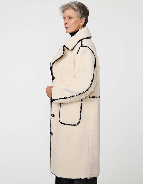 Calf-length faux fur coat with scalloped stitching, oversized lapels, and patch pockets for cozy sophistication.