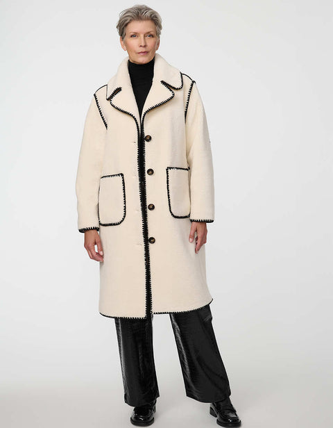 Calf-length faux fur coat with scalloped stitching, oversized lapels, and patch pockets for cozy sophistication.