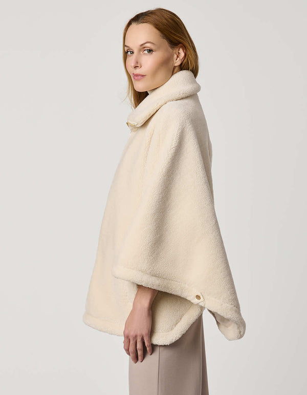 Oversized women’s sherpa poncho coat with zip-up collar, pull tabs, welt pockets, and oversized collar.