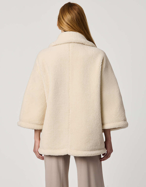 Oversized women’s sherpa poncho coat with zip-up collar, pull tabs, welt pockets, and oversized collar.