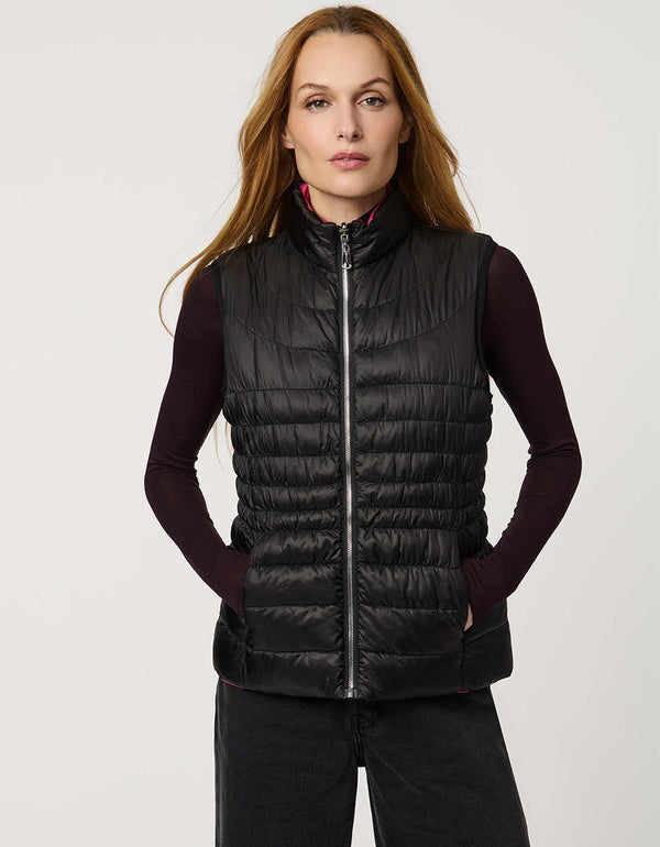 Women's black and pink reversible puffer vest for breast cancer awareness month. Lightweight for effortless layering.
