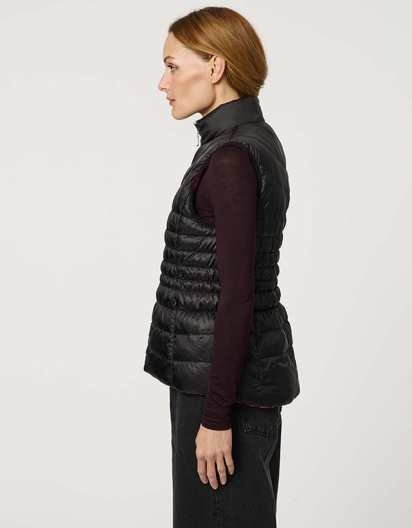 Women's black and pink reversible puffer vest for breast cancer awareness month. Lightweight for effortless layering.