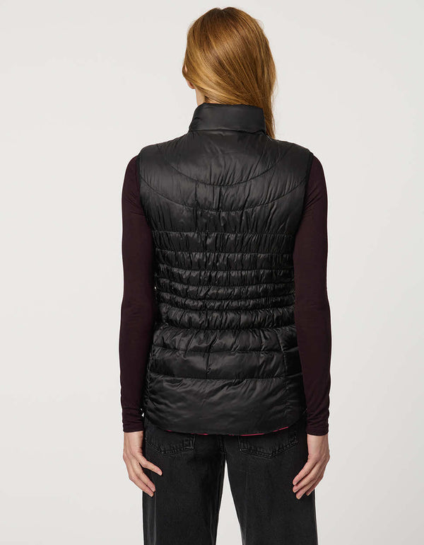 Women's black and pink reversible puffer vest for breast cancer awareness month. Lightweight for effortless layering.