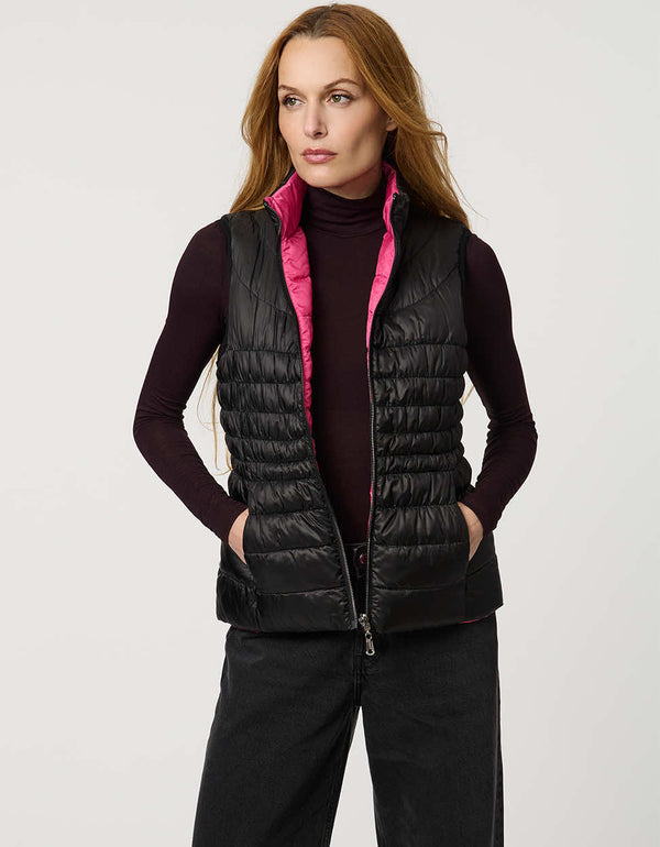 Women's black and pink reversible puffer vest for breast cancer awareness month. Lightweight for effortless layering.
