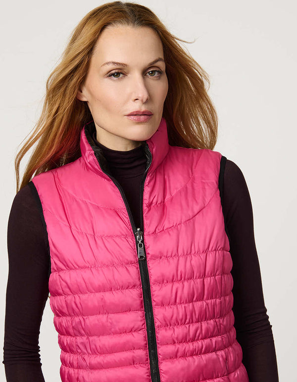 Women's black and pink reversible puffer vest for breast cancer awareness month. Lightweight for effortless layering.