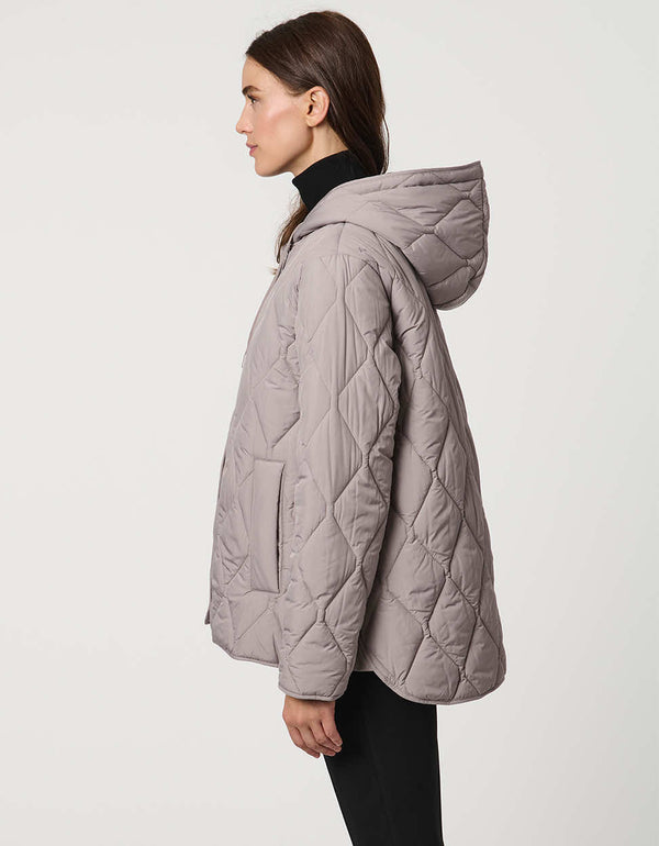 Oversized quilted puffer jacket with diamond stitching, drawstring hood, welt pockets, and snap front closures.