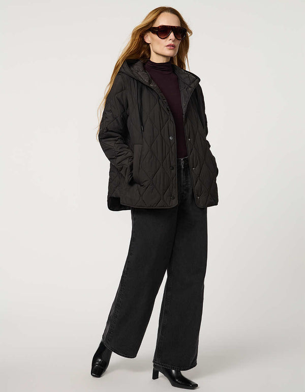 Oversized quilted puffer jacket with diamond stitching, drawstring hood, welt pockets, and snap front closures.