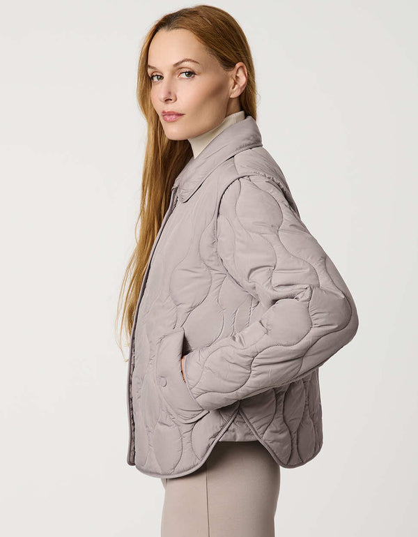 Classic quilted women’s puffer jacket with structured collar, snap closures, patch pockets, and Ecoplume fill.