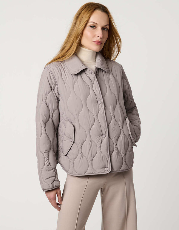 Classic quilted women’s puffer jacket with structured collar, snap closures, patch pockets, and Ecoplume fill.