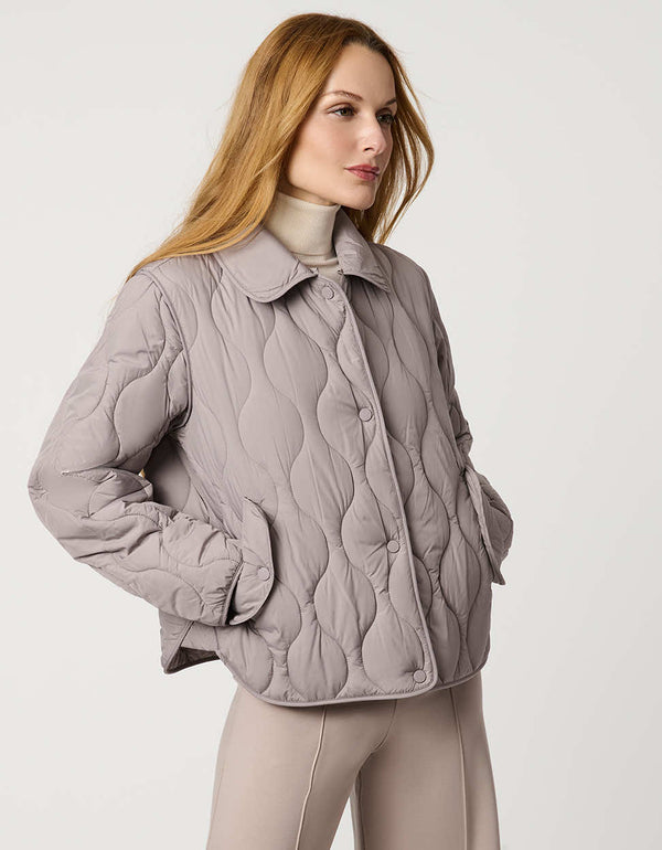 Classic quilted women’s puffer jacket with structured collar, snap closures, patch pockets, and Ecoplume fill.