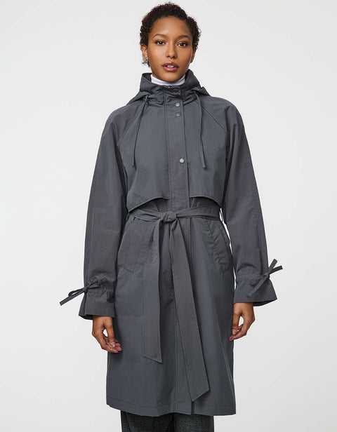 Calf-length women’s trench coat with belt, adjustable cuffs, and packable hood, ideal for transitional weather.