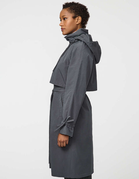 Calf-length women’s trench coat with belt, adjustable cuffs, and packable hood, ideal for transitional weather.
