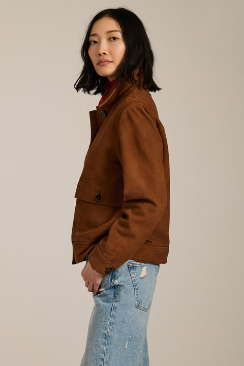 Genuine suede utility jacket with point collar, concealed button-front closure and oversized flap pockets.