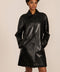 Women's black genuine leather car coat with point collar, button-front closure and side pockets.