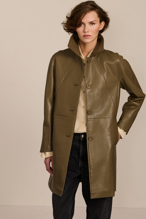 Women's genuine leather car coat with point collar, button-front closure and side pockets.
