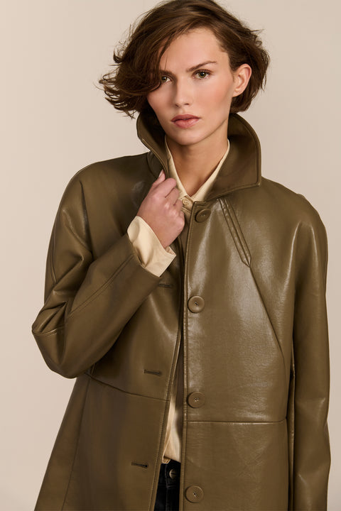 Women's genuine leather car coat with point collar, button-front closure and side pockets.
