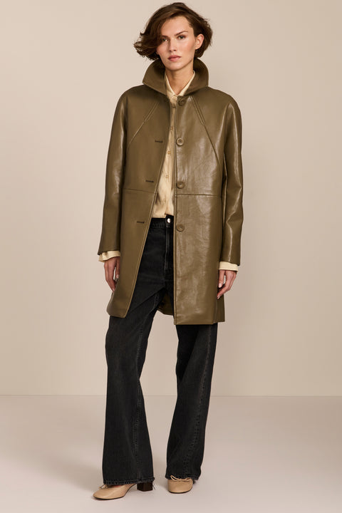 Women's genuine leather car coat with point collar, button-front closure and side pockets.