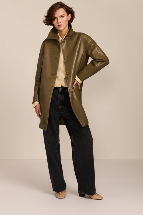 Women's genuine leather car coat with point collar, button-front closure and side pockets.