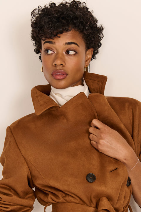 women's faux suede trench coat with a double-breasted front, notched lapels, belted waist and buckle cuff details.