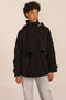 Women's hooded raincoat with drawstring waist, storm flap, side pockets and adjustable cuffs.