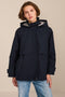 Women's hooded raincoat with drawstring waist, storm flap, side pockets and adjustable cuffs.