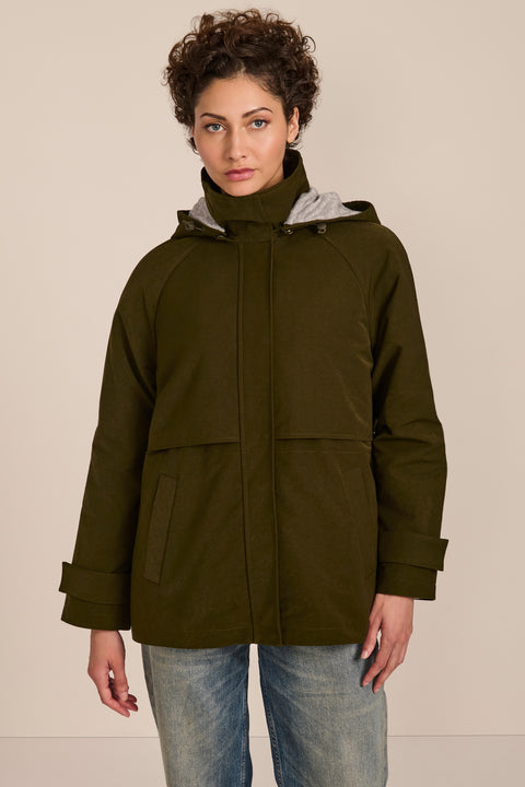 Women's hooded raincoat with drawstring waist, storm flap, side pockets and adjustable cuffs.